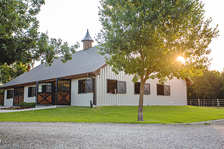 White barn with sunset behind it