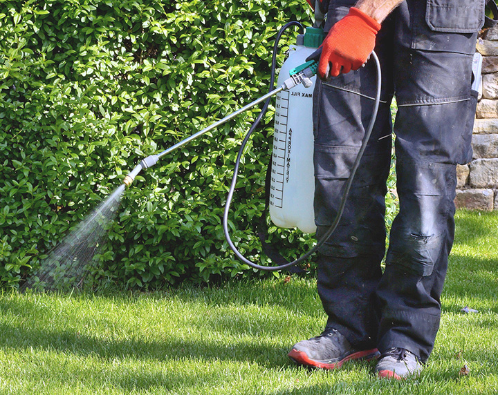 Man spraying fertilizer on a yard