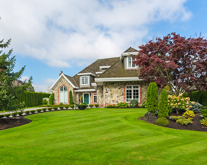 Brick house with a lush green yard